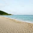 beach at buoy haus hotel in st thomas with green hills