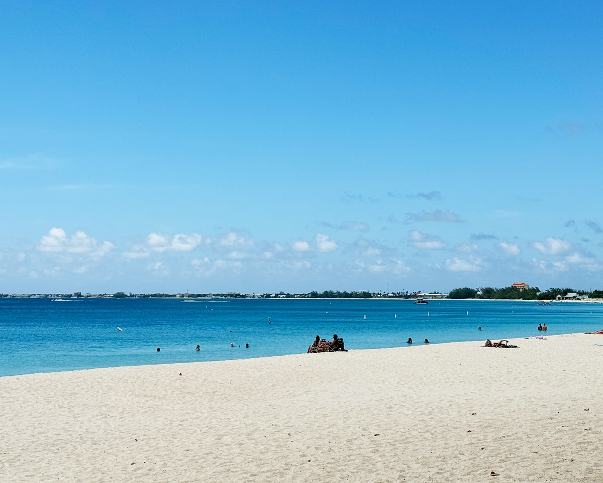 people sitting on seven mile beach in grand cayman